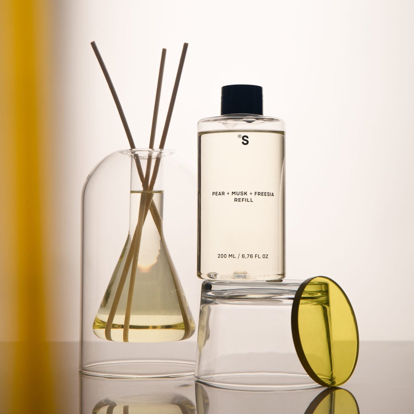 Sister's Aroma reed diffuser Pear + Musk + Freesia refill on a reflective surface