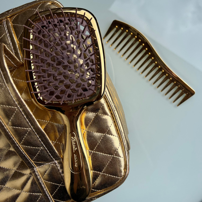 Gold Janeke hairbrush and comb set on a light blue background