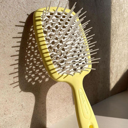 Janeke Yellow hairbrush with metal bristles on a textured surface