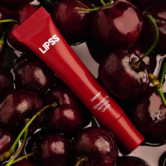 Red LIPSS lip balm Cherry tube surrounded by cherries on a dark background