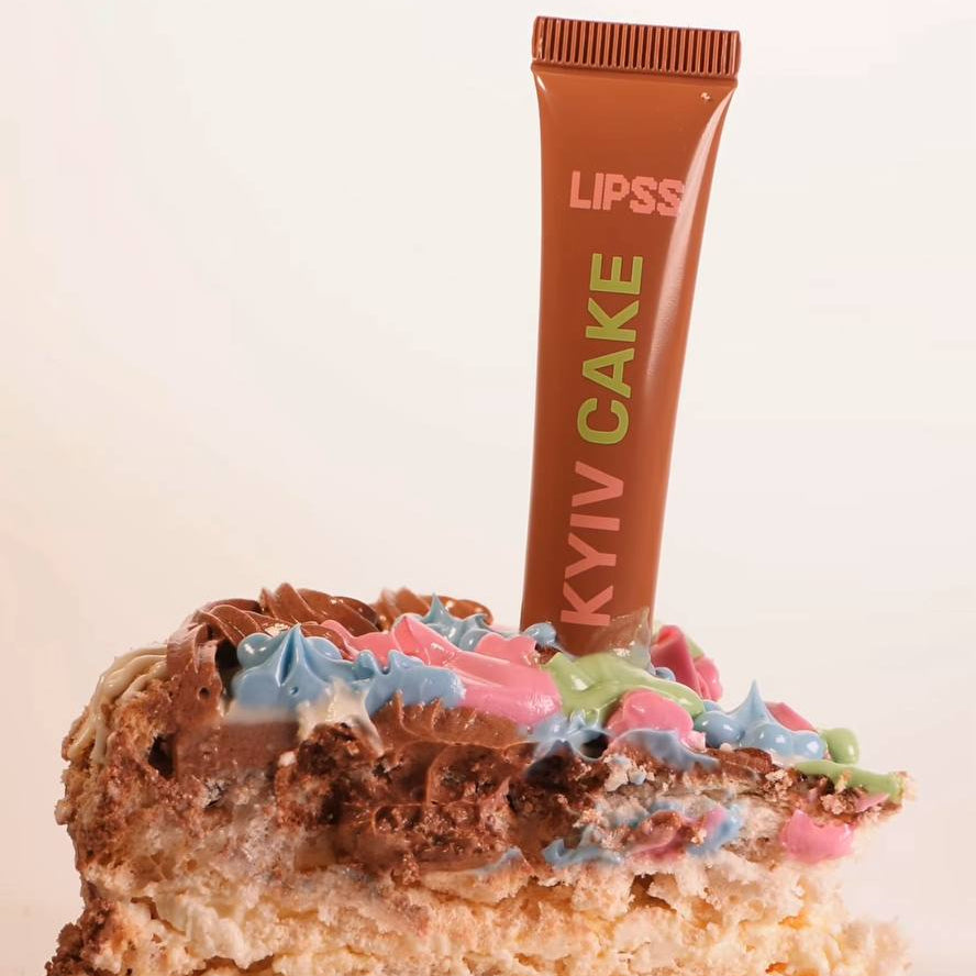 KYIV CAKE lip gloss on a piece of Kyiv cake with colorful frosting