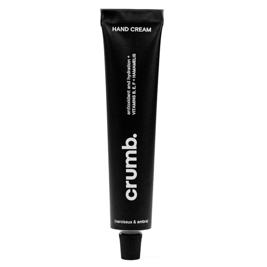 Black tube of crumb hand cream narcissus & ambra on a white background