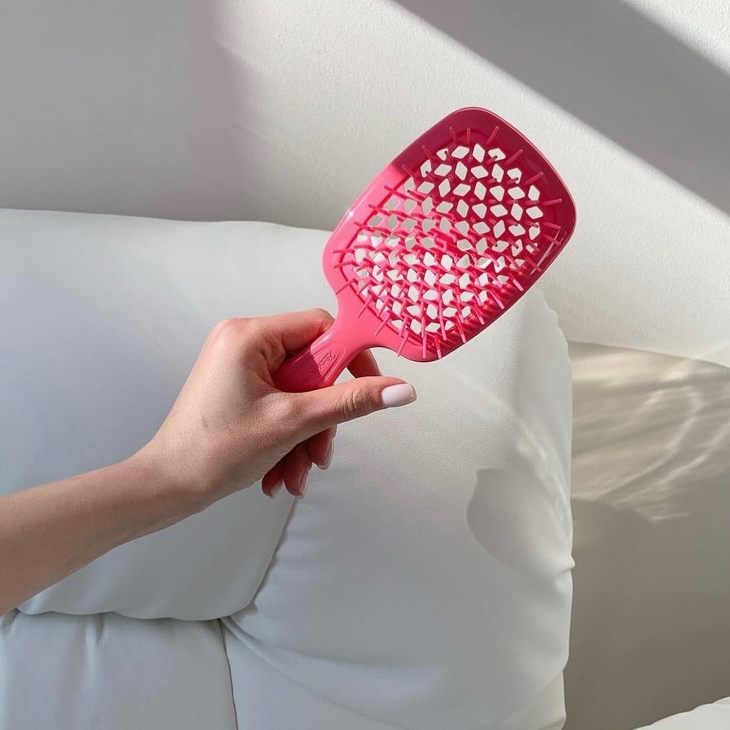 Hand holding a pink Janeke hairbrush